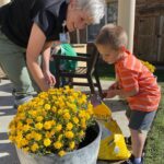 a child and woman watering flowers